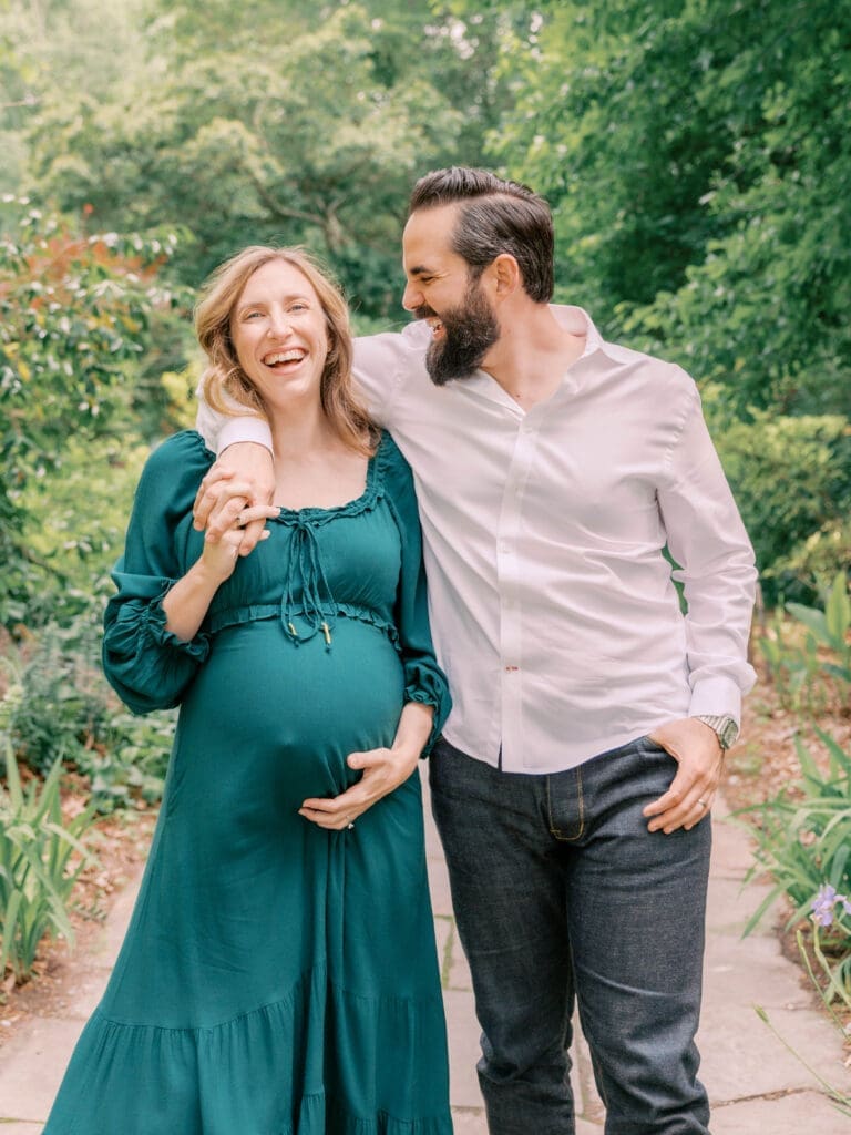 Couple laughing together during Duke Gardens maternity session in Durham, NC while expecting their first baby
