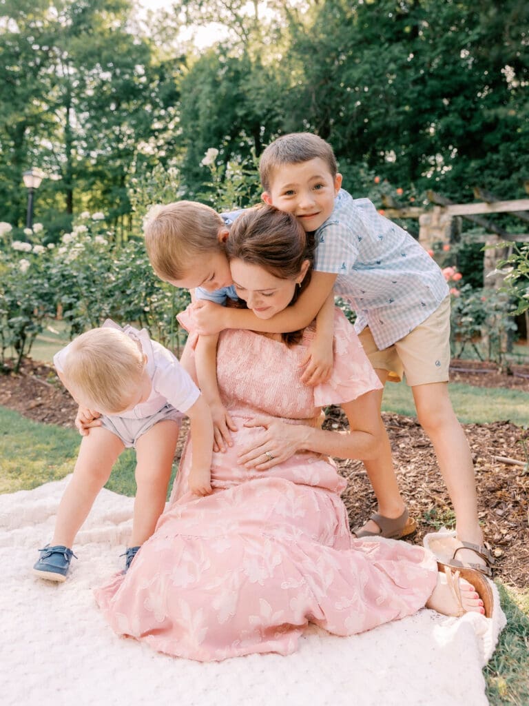 Pregnant mother sitting with her three sons during a playful maternity session in Raleigh, North Carolina