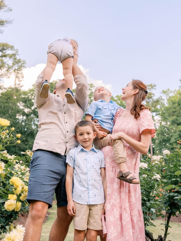 Growing family sharing a joyful moment during an outdoor maternity photography session in Raleigh
